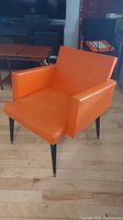 Front view of orange vinyl lounge chair
