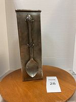 Front view of rectangular utensil holder showing large raised decorative spoon design.