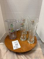 Photo of 4 Carlsberg UEFA Euro2012 Poland-Ukraine pint glasses and 1 pitcher on wooden base with a lot tag.