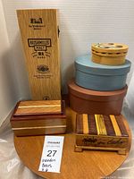 Overview of all six wooden boxes arranged on a wooden table showing diversity in styles and shapes