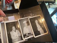 Photo of a hand holding several black and white vintage snapshots featuring 1940s movie stars in various poses, some with coats and hats.
