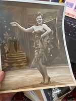 Photo of an 8x10 vintage black and white image of a burlesque dancer in stage costume posing with arms open