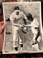 Photo of two baseball players from the Atlanta Braves in striped uniforms shaking hands on the field.