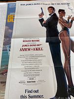 Poster of "A View to a Kill" featuring Roger Moore as James Bond, with a woman in a black dress, clean image with minor creases.