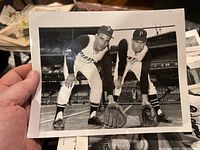 Photo showing two Pittsburgh Pirates players posed in ready fielding position on a baseball field, shot in black and white.