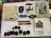 Photo showing the entire collection including letters, patches, photos, ribbons, buttons, and postcard.