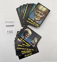 Top-down view of two stacks of colorful Outer Limits trading cards depicting sci-fi monsters and creatures from the 1960s with descriptive titles in yellow text.