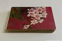 Stack of vintage linen postcards with floral design on top