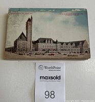 Stack of vintage postcards with a cover card showing a historical building with a tall clock tower.