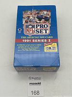 Front view of the sealed 1991 NFL Pro Set Series 1 box featuring the NFL logo, player images, and text detailing 14 photo and stat cards plus the included playbook.