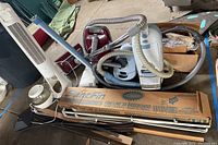 Photo showing multiple vacuum cleaners, boxed baseboard heater, tower fan, and humidifier grouped together