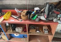 Shelf with miter saw, yellow trays, boxes with tools and hardware items