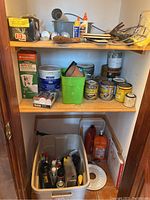 Overview of shelves showing assorted paint cans, potting mix, plastic containers, nails, and various hardware supplies.