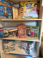 Shelf display of the children's science and creative toys, including Wired Science, Crayola Color Wonder, LEGO City truck set, Secret Formula Lab, Bug Discovery Lab, Microscope, Gertie toy, and Toy in Soup.