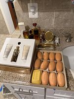 Perfume bottles, boxed soap bars, and boxed gift set with lotion and shower gel displayed on a bathroom countertop