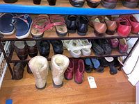 Photo showing the three rows of shoes on shelves and floor, including UGG boots, sandals, loafers, and ankle boots.