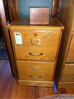 Front view of the wooden 2-drawer file cabinet with the wooden box on top showing the cabinet condition and hardware.
