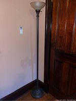 Full view of the metal floor lamp, showing height and general structure.