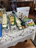 Shows four Hess trucks, two horse puzzles, and Quoridor game box arranged on a table.