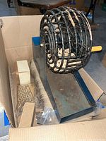 Full view of the vintage wire ball cage bingo machine with metal base and yellow handle crank