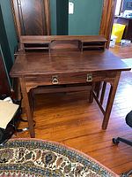 Front view of wooden desk with attached hutch and drawer on slatted legs