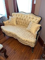 Full front view of sofa with pillows against wall and hardwood floor