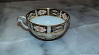 Photo of the Royal Crown Derby England tea cup showing the floral and gold decorative pattern.