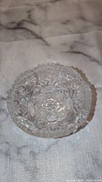 Top view of the clear crystal display bowl showing floral and geometric cut patterns.