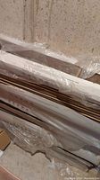 Stacked closed boxes of 12mm laminate flooring in packaging with visible labeling and wrapped in plastic.