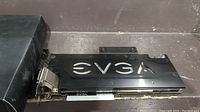 Side view of the EVGA video card showing black metal casing and ports with EVGA logo cutout.