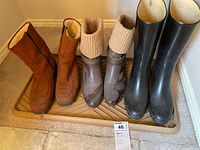 Four boots shown side by side on a tray: one pair tall black rain boots, two pairs brown winter boots with knitted cuffs and suede/leather material.