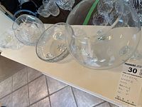 Photo showing two clear crystal bowls, one with three feet and a smaller size, the other larger and rounder with similar cut patterns