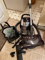 Full view of Kenmore 600 Series canister vacuum cleaner set upright showing vacuum canister, hose attached to main wand, floor brush, and accessories bag with cleaning attachments.