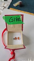 Pair of carnelian stud earrings in presentation box with green G18K tape