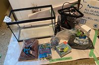 Various aquarium supplies laid out including gravel bags, Rena Air 50 box, clear tubing, and air pump.