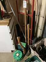 Photo showing red hand truck dolly, wooden handled axe and mallet, green frog designed planter, and several black metal cones