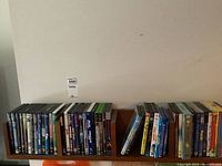 Photo showing assortment of DVDs arranged on shelf, including several family and animated movie titles.