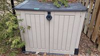 Full front view of Keter heavy duty outdoor storage shed with closed double doors, beige with black top and base.