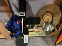 Full lot overview showing metal detector, vintage lighter, shoe trees, hat, bucket, and other associated items on a shelf.