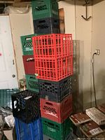 Stacked plastic milk crates in multiple colors in basement setting.