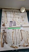 Overview of all gold tone necklaces laid out showing multiple styles and pendants