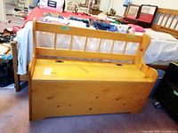 Front view of pine storage bench showing backrest with vertical slats and closed seat