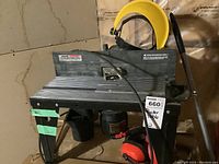 Sears Craftsman router table with power cord, yellow face shield, and red earmuffs in basement setting