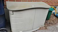 Front view of Rubbermaid outdoor cabinet showing two doors and curved lid.