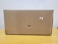 Sealed cardboard box packaging, generic with fragile label.