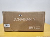 Original sealed box of Jonathan Y brand wall sconce with label visible, showing model number JYL7462A