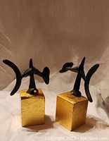 Pair of sculptures viewed together on draped cloth background