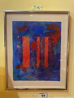 Full view of the framed artwork showing red vertical stripes on a blue and purple background with a silver frame.
