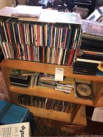Overview of multiple shelves filled with CDs and DVDs in cases, showing quantity and storage style.