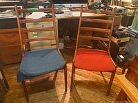 Front view of both ladder-back chairs showing seat colors and frame design